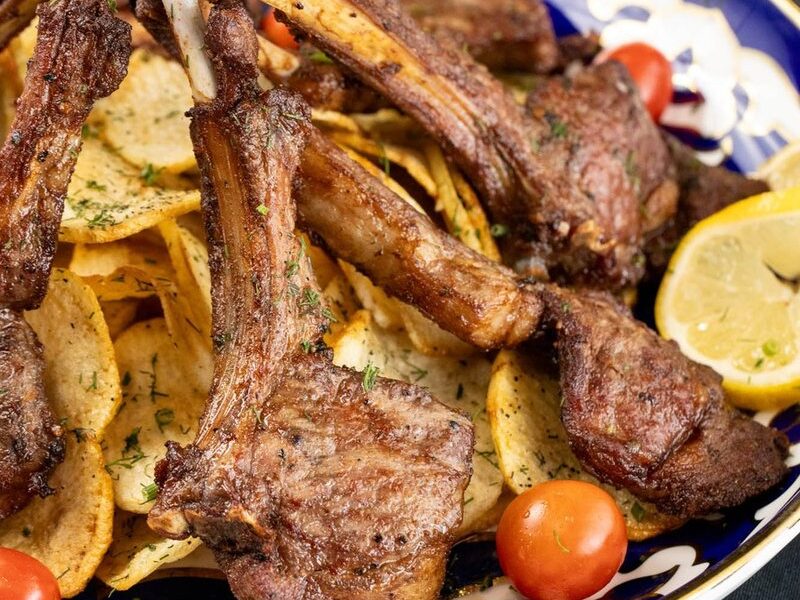 Old Bukhara lamb chops with crispy potatoes on a traditional Uzbek plate